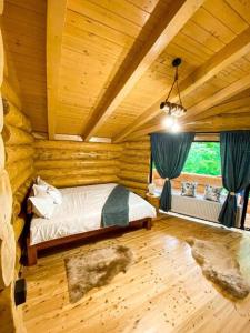1 dormitorio con 1 cama en una cabaña de madera en Perla Chiuzbaii, en Baia-Sprie