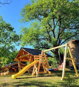 um parque infantil com escorrega em frente a uma casa em Perla Chiuzbaii em Baia Sprie