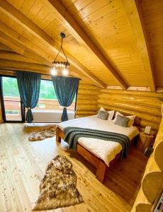 a bedroom with a bed in a wooden room at Perla Chiuzbaii in Baia-Sprie