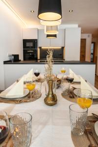 a table with a white table cloth with wine glasses at AUSZEIT Apartments in Oberau