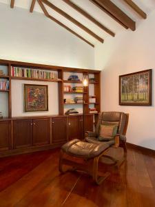 uma sala de estar com uma cadeira e uma estante de livros em Casa Chipre By Wynwood House em Medellín