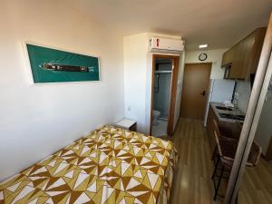 Cette petite chambre comprend un lit et une cuisine. dans l'établissement Studio Aconchegante com vista mar no Smart Pituba, à Salvador
