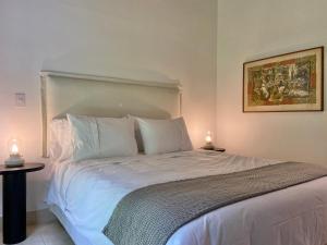 um quarto com uma grande cama branca e 2 candeeiros em Casa Chipre By Wynwood House em Medellín