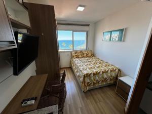 - une chambre avec un lit et une grande fenêtre dans l'établissement Studio Aconchegante com vista mar no Smart Pituba, à Salvador