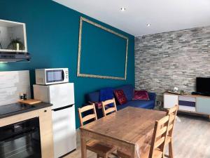 een keuken met een tafel en een blauwe muur bij Appartement de 2 chambres avec terrasse et wifi a Meaux in Meaux