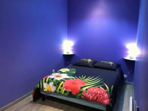 een paarse slaapkamer met een bed met bloemen erop bij Appartement de 2 chambres avec terrasse et wifi a Meaux in Meaux