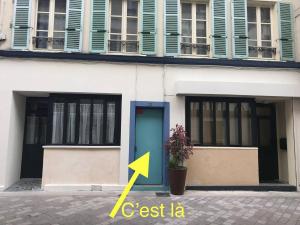 een gebouw met een blauwe deur en een groene pijl bij Appartement de 2 chambres avec terrasse et wifi a Meaux in Meaux