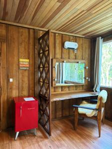Zimmer mit einem Schreibtisch, einem Spiegel und einem Stuhl in der Unterkunft Chácara Caminho das Águas in Piraquara