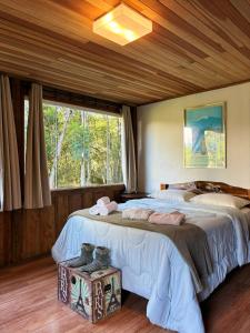 a bedroom with two beds and a large window at Chácara Caminho das Águas in Piraquara