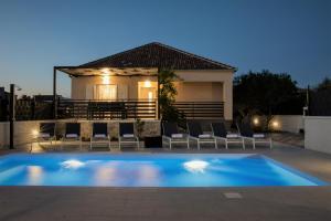 una piscina con sedie e una casa di Villa Residence Sunrise a Privlaka (Brevilacqua)