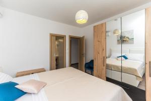 una camera bianca con 2 letti e uno specchio di Villa Residence Sunrise a Privlaka (Brevilacqua)