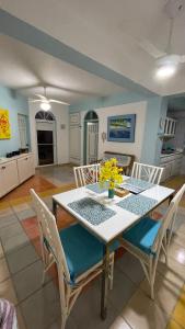 a dining room table and chairs with yellow flowers on it at Caribbean Paradise steps to DayPass Resort&Beach in La Laguna