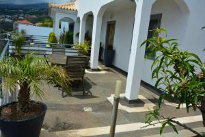 a porch of a white house with plants at 3 bedrooms house with private pool terrace and wifi at Funchal 3 km away from the beach in Funchal