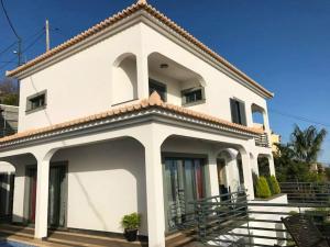 a white house with a roof at 3 bedrooms house with private pool terrace and wifi at Funchal 3 km away from the beach in Funchal