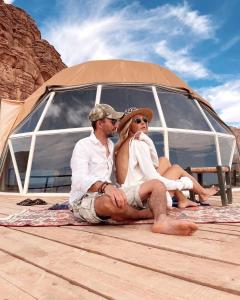 a man and a woman sitting under a tent at RUM HiLTON lUXURY CAMP in Wadi Rum