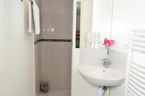 ein weißes Badezimmer mit einem Waschbecken und einem Spiegel in der Unterkunft Résidence Les Pleiades - 3 Pièces pour 8 Personnes 54 in Flaine