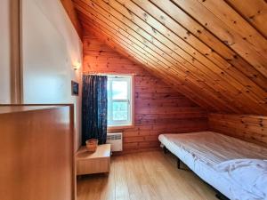 een slaapkamer met een bed in een houten kamer bij Résidence Hameau - Chalets pour 8 Personnes 53 in Flaine