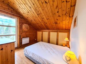 a bedroom with a bed and a wooden ceiling at Résidence Hameau - Chalets pour 8 Personnes 57 in Flaine