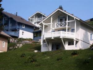 a large white house on top of a hill at Résidence Hameau - Chalets pour 8 Personnes 57 in Flaine