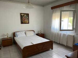 a bedroom with a bed and a window at Monastiraki Villa in Keramoti