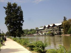 a person walking down a sidewalk next to a river at Departamento Capital Mendoza 2 3 in La Cieneguita
