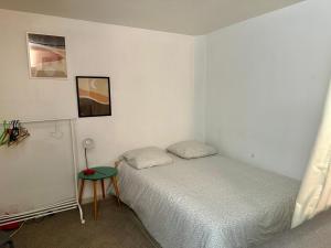 a small bedroom with a bed and a table at Aubervilliers maison de ville près métro 7 by immo kit bnb in Aubervilliers