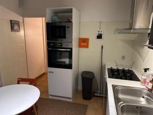 a small kitchen with a stove and a microwave at Aubervilliers maison de ville près métro 7 by immo kit bnb in Aubervilliers