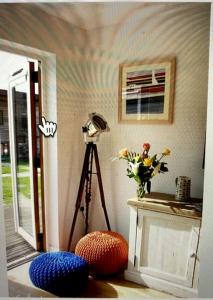 a room with a tripod and a vase of flowers at Valentyne Beach House in Porthtowan