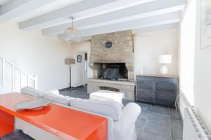 a living room with white furniture and a fireplace at KER HIR - Charmante maison bretonne tout confort in Landunvez