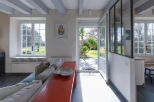 ein Wohnzimmer mit einem Sofa und einem Tisch in der Unterkunft KER HIR - Charmante maison bretonne tout confort in Landunvez