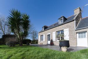 a brick house with a palm tree in front of it at KER HIR - Charmante maison bretonne tout confort in Landunvez