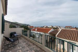 a balcony with a view of the roofs of buildings at Peaceful Retreat in Mosteiros