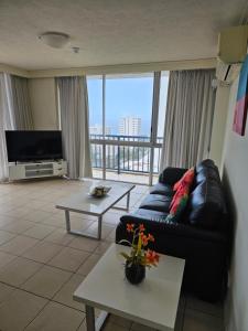 a living room with a couch and a large window at Centrepoint Resort in Gold Coast