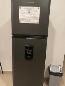 una nevera negra con un dispensador de agua. en Plataview Apartahotel apt 3A, en Monte Plata