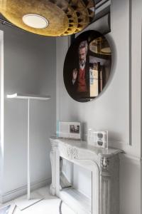 a round mirror above a white table in a room at BDB Rooms Margutta in Rome