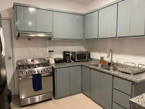 a kitchen with a stainless steel stove and a microwave at Plataview Apartahotel apt 3A in Monte Plata
