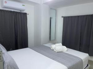 1 Schlafzimmer mit 2 Betten, einem Spiegel und Vorhängen in der Unterkunft Plataview Apartahotel apt 3A in Monte Plata