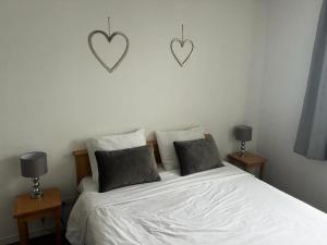 een slaapkamer met een bed met twee harten aan de muur bij Résidence Les Pleiades - 2 Pièces pour 4 Personnes 93 in Flaine