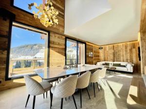 a dining room with a large glass table and chairs at Chalet - Chalets 101 in Notre-Dame-de-Bellecombe