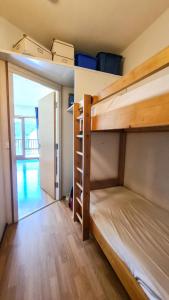 two bunk beds in a room with a hallway at Résidence Andromede - Studio pour 4 Personnes 05 in Flaine