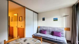 a bedroom with a bed with purple pillows in it at Résidence Doris - Studio pour 4 Personnes 04 in Flaine