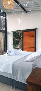 1 dormitorio con 1 cama grande y cabecero de madera en Cabaña ATARDECER con vista al Río, en La Vega