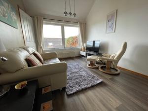 a living room with a couch and a chair at Hillside View, Inverness in Inverness