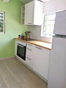 a kitchen with white appliances and a window at Appartement - Résidence piscine La Villa Bèl in Sainte-Anne