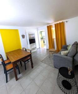 ein Wohnzimmer mit einem Tisch und einem Sofa in der Unterkunft Appartement - Résidence piscine La Villa Bèl in Sainte-Anne