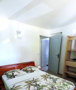 a bedroom with a bed and a blue door at Appartement - Résidence piscine La Villa Bèl in Sainte-Anne