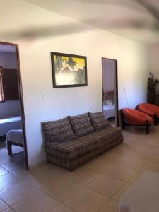 ein Wohnzimmer mit einem Sofa und einem Bild an der Wand in der Unterkunft Casa Tucunaré in Três Marias