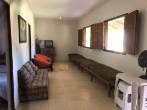 ein Wohnzimmer mit einem Sofa, einem Tisch und einem Fenster in der Unterkunft Casa Tucunaré in Três Marias