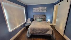 a blue bedroom with a bed and a window at Home Stay in Atlanta