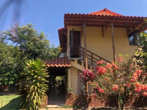 Casa con balcón y algunas flores en Casa Tucunaré en Três Marias